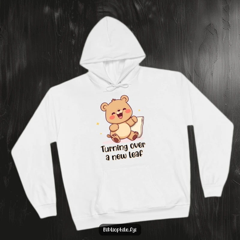 Funny hoodie with a cheerful bear character actively flipping a large page, embodying excitement for the next chapter, great for readers.