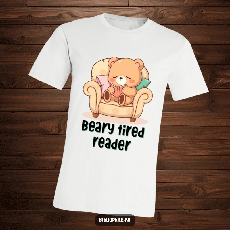 Funny Sleepy Bear T-Shirt featuring a sleepy bear character curled up on a comfortable armchair made of pillows, reading, perfect for relaxation.